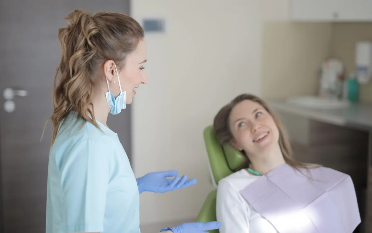 Dentista conversando com paciente durante a consulta