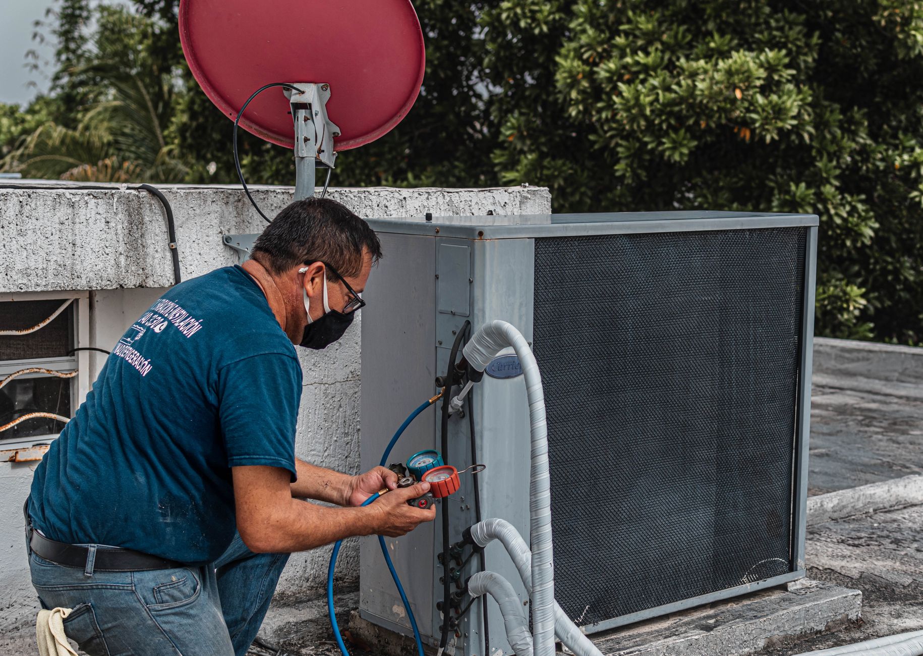 Técnico fazendo manutenção em unidade de ar-condicionado no telhado