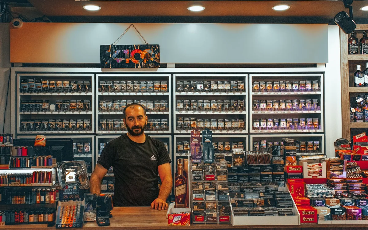 Vendedor mostrando tela do celular no balcão da loja
