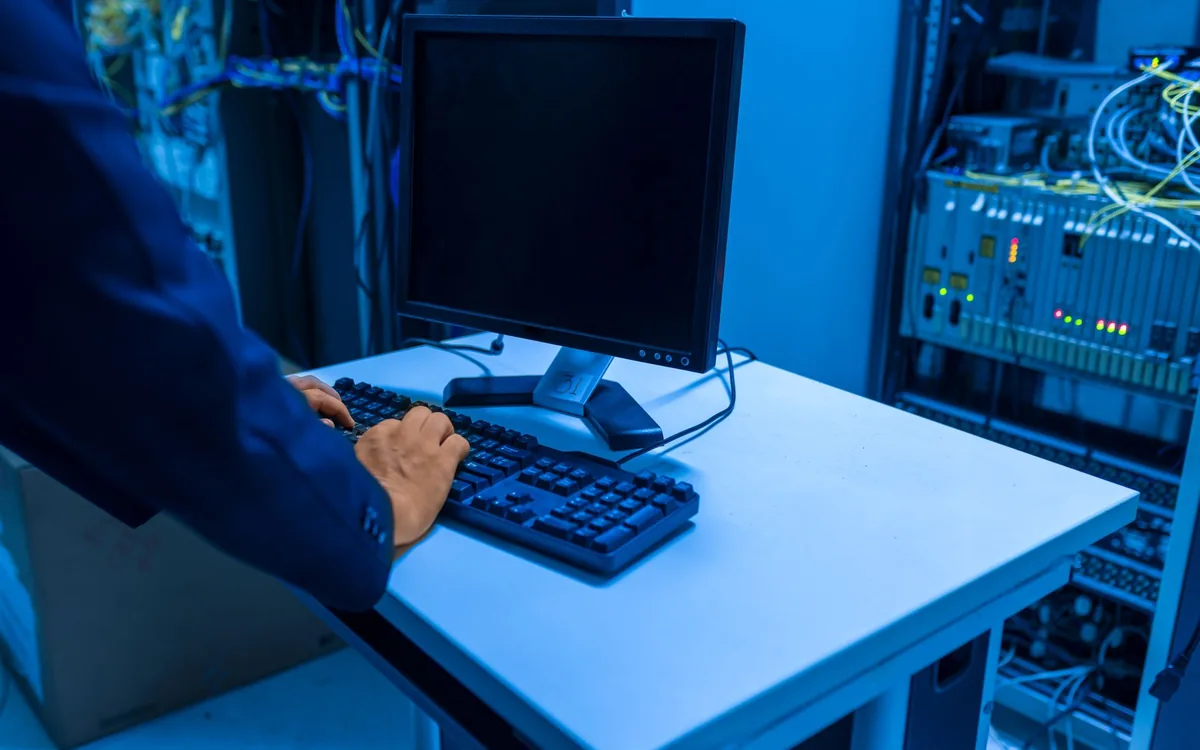 Técnico de redes testando velocidade em notebook dentro de loja