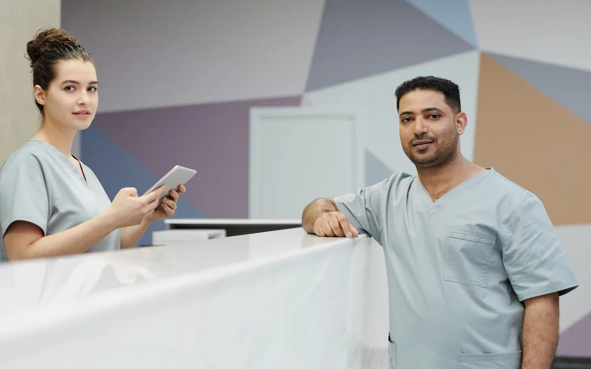 Recepcionista atendendo no balcão de uma clínica