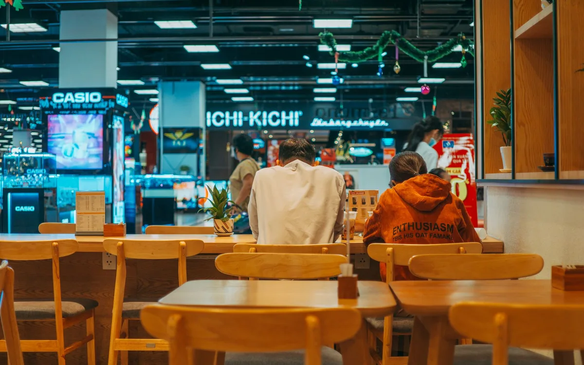 Der Food Court eines Einkaufszentrums mit sitzenden Menschen