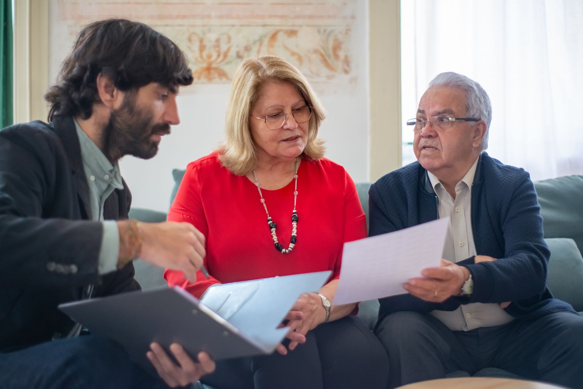 Consultor mostrando documento para casal de clientes