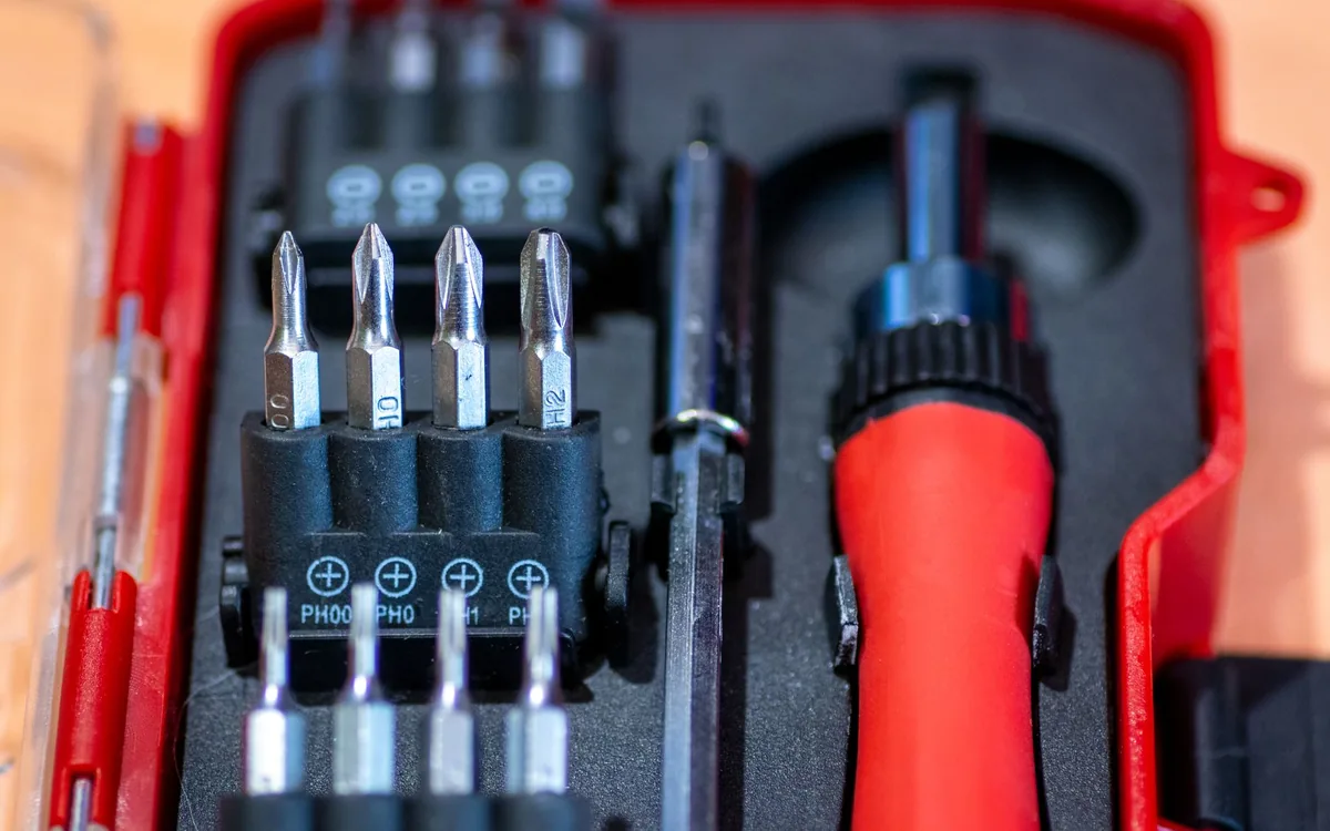 Técnico com celular e caixa de ferramentas