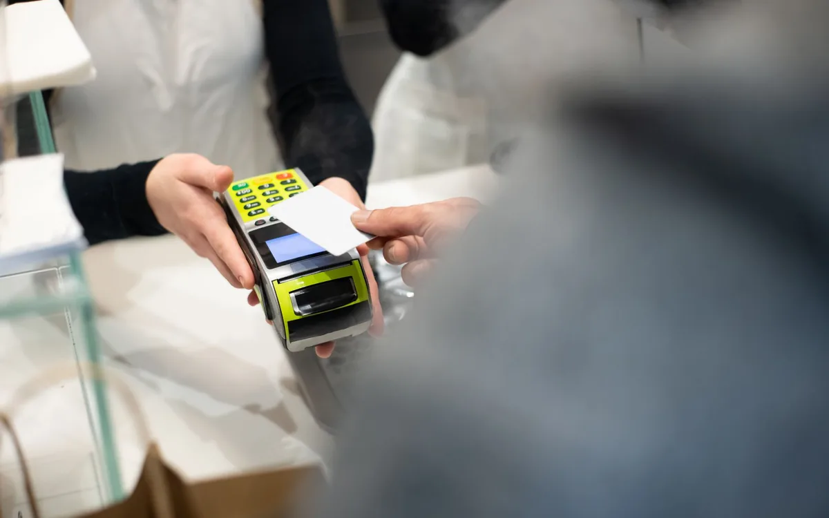 Vendedor apresentando máquina de cartão pro dono da loja