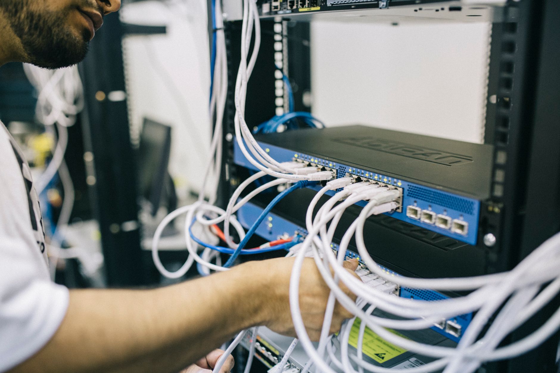Técnico conectando cabo de rede em switch