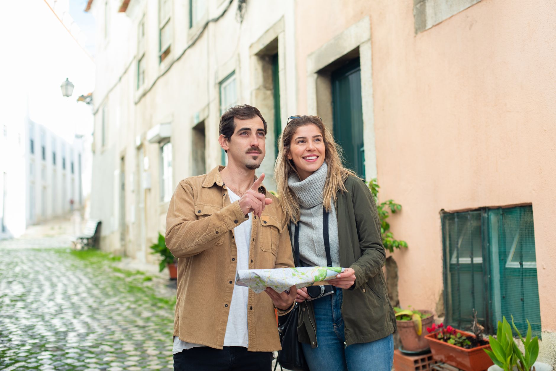 Casal de turistas com mapa em rua de paralelepípedo