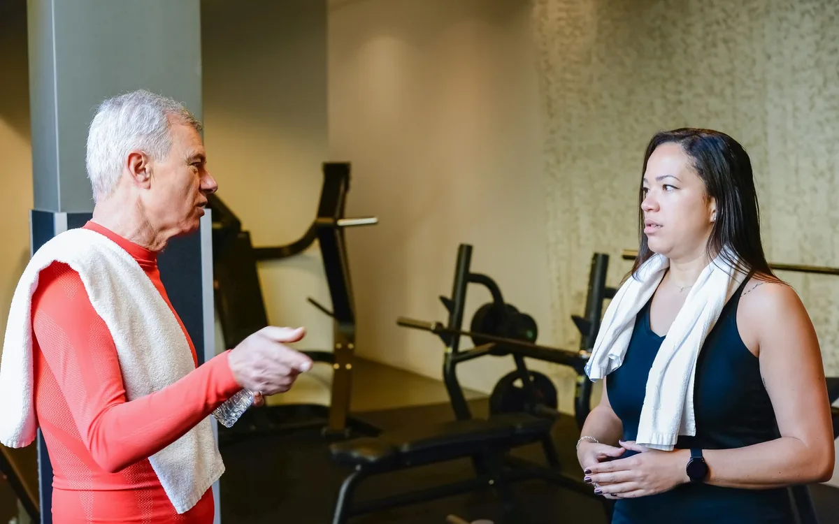 Un entrenador orientando a un socio en el gimnasio