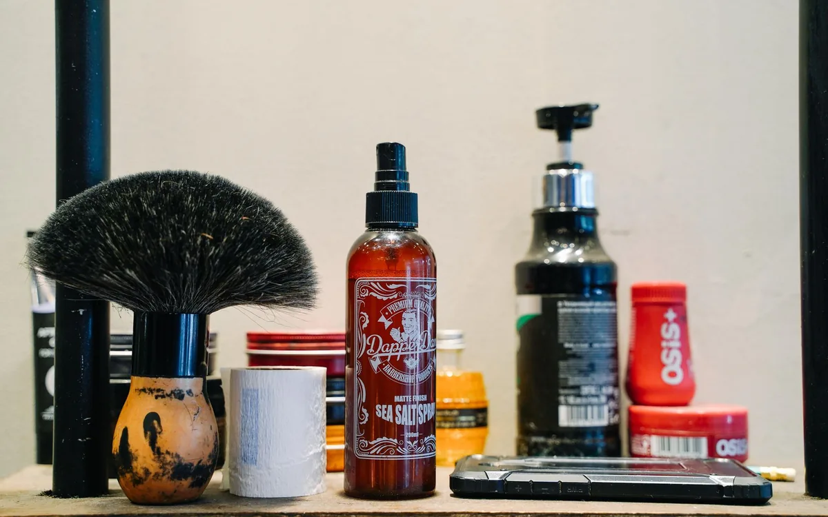 Une étagère de cires et de produits de soin dans un salon de barbier